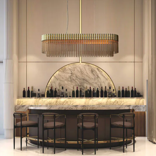 High End Modern Oval Chandelier A modern, elegant bar with a marble counter and a high arc of shelves displaying wine bottles. Four dark chairs are placed in front of the counter. Above, a large High End Modern Oval Chandelier with vertical elements provides ambient lighting.