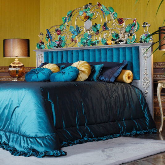 High End Venetian Style Tropical Brass Bed A High End Venetian Style Tropical Brass Bed adorned with blue bedding and complemented by a stylish lamp.