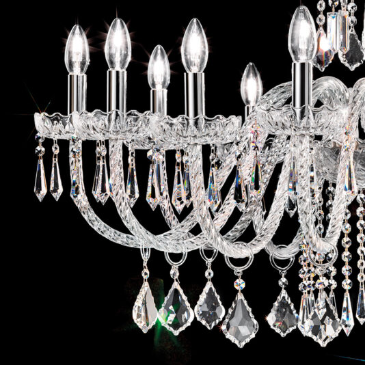 Large Blown Glass Chandelier With Crystal Drops A close-up of the Large Blown Glass Chandelier With Crystal Drops showcases its six candle-shaped light bulbs. The chandelier features intricate detailing and numerous crystal drops, all beautifully illuminated and sparkling against a dark background.