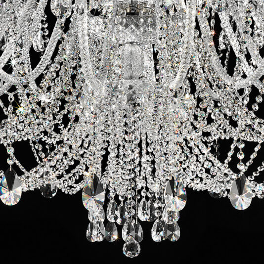 Large Crystal Chandelier With Shades A close-up image showcases the Large Crystal Chandelier With Shades, highlighting its numerous cascading crystal drops and intricate glass beads. The chandelier's design reflects light beautifully, creating a sparkling effect against a dark background.
