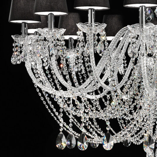 Large Crystal Chandelier With Shades The Large Crystal Chandelier With Shades showcases an ornate design with intricate details and multiple branches adorned with sparkling crystals and elegant black lampshades. The chandelier's crystals cascade down in elaborate arrangements, reflecting light beautifully against a dark background.