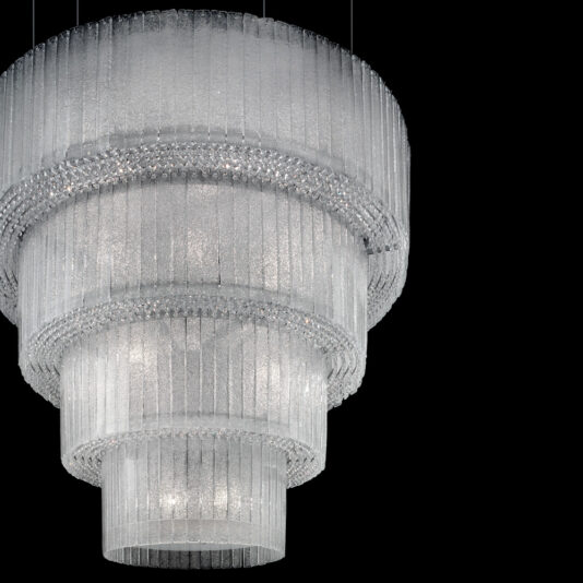 Large Modern Tiered Glass Chandelier An image showcases the Large Modern Tiered Glass Chandelier, hanging gracefully against a black background. This chandelier features multiple layers of vertical crystal prisms, offering a dramatic and luxurious allure. Each tier radiates light that shimmers off the crystals, enhancing its elegant presence.