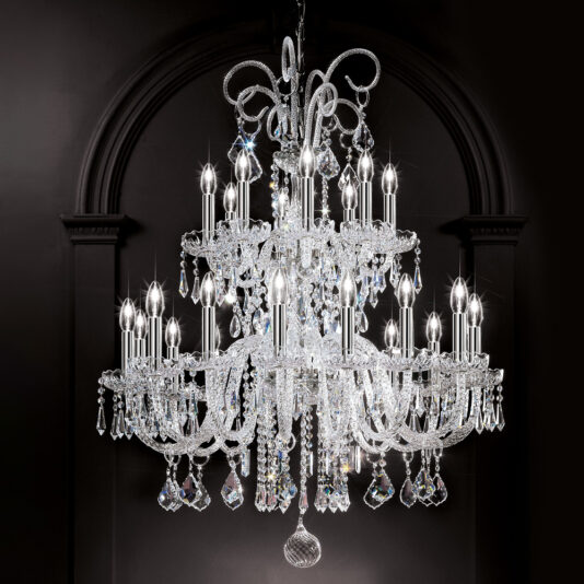 The Large Two Tier Blown Glass Chandelier With Crystals shines brightly against a dark background, featuring intricate designs and dangling crystal prisms that create a luxurious and elegant appearance with its numerous candle-shaped lights.