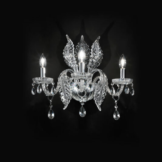 Luxury Acanthus Triple Glass Wall Light The Luxury Acanthus Triple Glass Wall Light emits a soft glow against a black background. Each arm is adorned with intricate crystal leaf designs and dangling crystal ornaments, showcasing the elegant and ornate craftsmanship of the fixture.