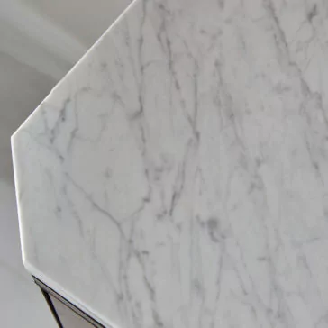 A close-up of the Luxury Marble Top Veneer Sideboard showcases its exquisite marble table top with light gray veining against a white background, revealing the detailed texture and natural patterns. The beveled edge creates a subtle shadow, accentuating the sideboard's substantial thickness and masterful craftsmanship, reminiscent of classic veneers on an elegant sideboard.