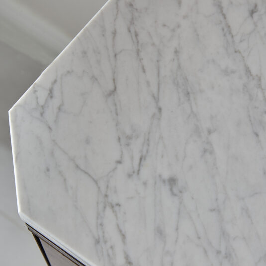 Luxury Marble Top Veneer Sideboard A close-up of the Luxury Marble Top Veneer Sideboard showcases its exquisite marble table top with light gray veining against a white background, revealing the detailed texture and natural patterns. The beveled edge creates a subtle shadow, accentuating the sideboard's substantial thickness and masterful craftsmanship, reminiscent of classic veneers on an elegant sideboard.
