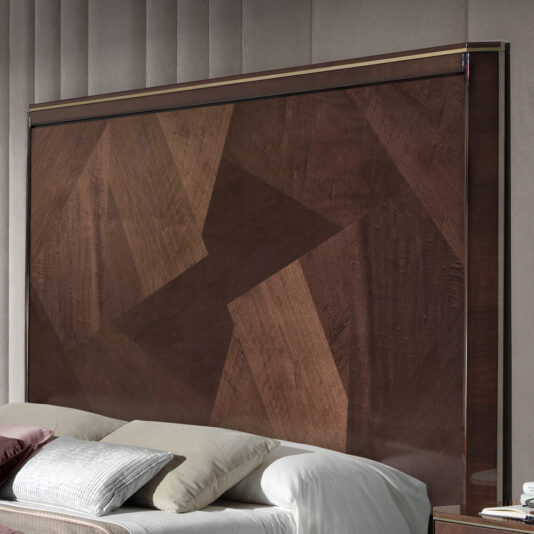 A close-up shot of the Luxury Bed With Tall Brown Maple Headboard showcasing its stylish geometric pattern in varying shades of brown. The modern bed setup features a neatly made bed adorned with a beige pillow and a burgundy pillow.