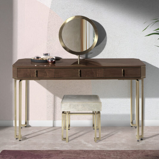 The Luxury Brown Maple Veneer Vanity Table is a modern, luxury vanity set with metal accents. It features a circular mirror and several small items arranged on the left side of the brown maple veneer tabletop. Beneath the table is a cushioned stool with matching metal legs. The setup is complemented by light-colored walls and a plant in the background.