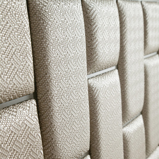 The Luxury Panel Upholstered Bed features a textured beige surface with woven fabric panels, reminiscent of an upscale upholstered finish. Its grid pattern offers a geometric and modern appeal, while the slightly raised panels enhance depth and dimension.