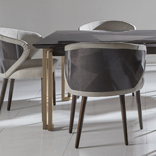 Luxury Veneer And Brass Extendable Dining Table A modern dining area featuring the Luxury Veneer And Brass Extendable Dining Table with four cushioned chairs. The chairs have wooden legs and are upholstered with light-colored fabric and dark mesh backs. The floor is glossy white tile, and the walls are light gray.