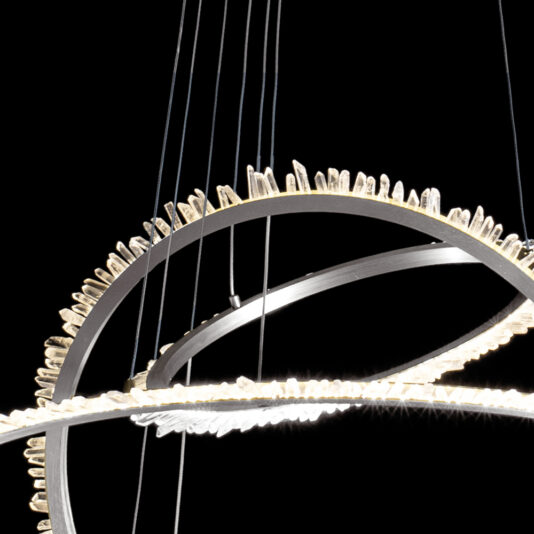 Modern Nickel Quartz Crystal Hoop Chandelier A close-up of the Modern Nickel Quartz Crystal Hoop Chandelier shows two interlocking black rings adorned with glistening quartz crystal-like spikes, suspended by thin cables against a black background, creating an elegant and contemporary design.