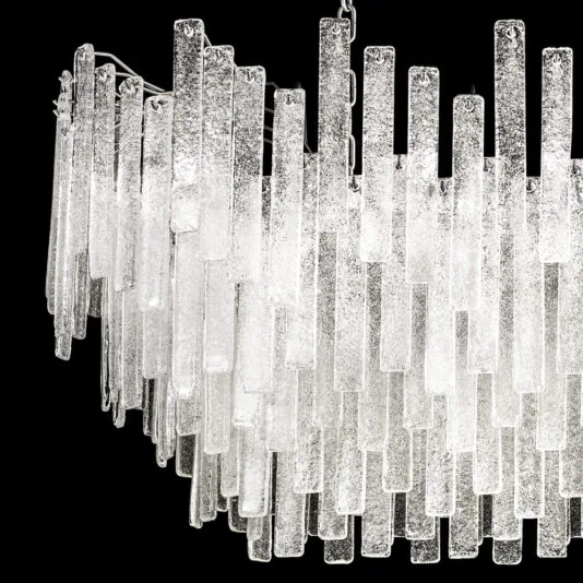 Modern Oval Glass Chandelier Introducing the Modern Oval Glass Chandelier: A contemporary and elegant lighting fixture featuring an array of vertically aligned, elongated glass pendants. The textured glass pieces are arranged in layered rows, creating a cascading effect against a sleek black background.