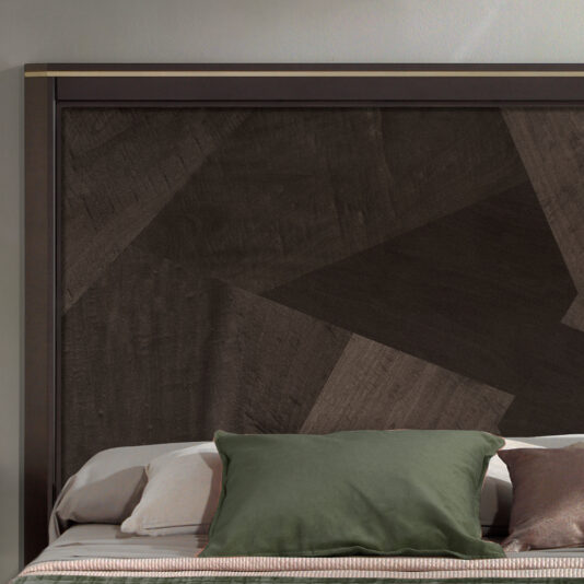 Opulent Brown Maple Veneer Bed The Opulent Brown Maple Veneer Bed is a modern, luxurious piece featuring a padded dark wooden headboard. The bed is impeccably made with white sheets and two white pillows, with a green pillow placed in the center. The headboard showcases geometric patterns, adding an elegant touch to the overall design.
