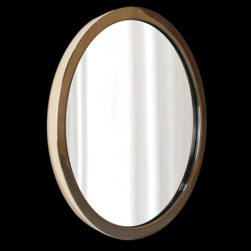 Round Modern Wall Mirror The Round Modern Wall Mirror, featuring a gleaming gold frame, beautifully reflects a simple white background. Set against a plain, black backdrop, the mirror accentuates its sleek and minimalist design.