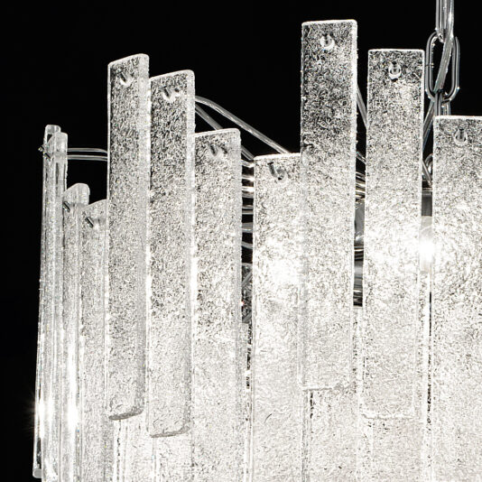 Small Modern Glass Chandelier A close-up of the Small Modern Glass Chandelier showcases its elongated, textured glass panels arranged vertically and overlapping to reflect light and produce a sparkling effect. The dark background accentuates the intricate details of the glass.