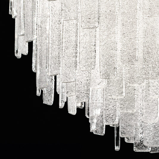 Small Modern Glass Chandelier A close-up of the Small Modern Glass Chandelier showcases its sophisticated design, featuring multiple elongated, rectangular glass pieces suspended in a cascading pattern. The textured glass elements catch and reflect light beautifully against the dark background, adding an elegant touch to the space.