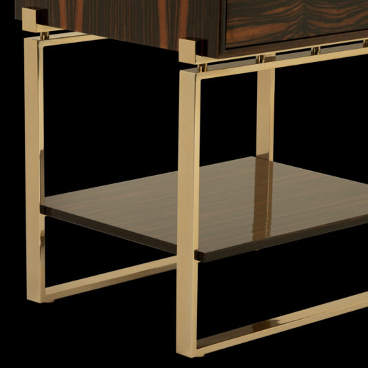 The Veneered Art Deco Inspired Bedside Table boasts a polished wood surface and sleek gold metal legs, offering a modern, sophisticated design. Its clean lines and rich wood finish beautifully contrast with the metallic accents, while the additional lower shelf provides extra storage space.