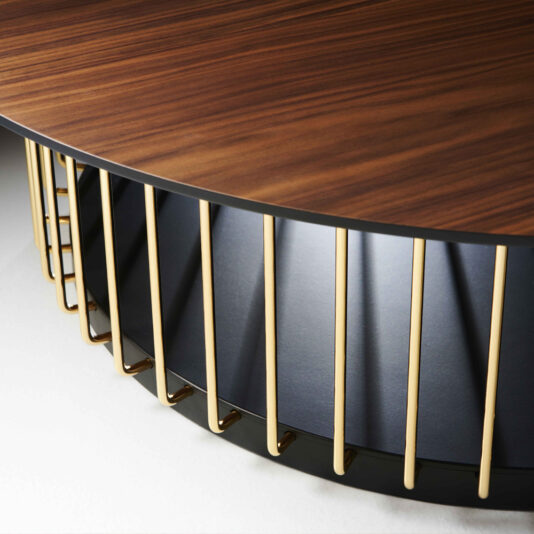 Close-up view of the Contemporary Round Wooden Coffee Table, showcasing its dark brown top and an eye-catching base design made up of vertically aligned, gold-colored metal rods. These rods encircle the base, contributing to an attractive, modern aesthetic.