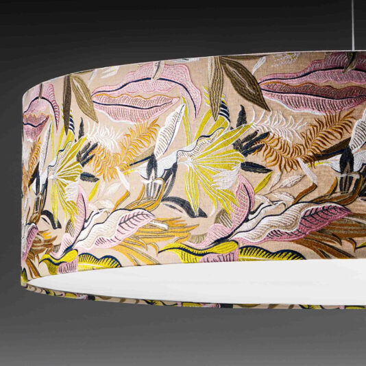 Elegant Suspension Light With Embroidered Shade The Elegant Suspension Light With Embroidered Shade features a hanging cylindrical lampshade adorned with a colorful floral and botanical pattern in shades of pink, yellow, green, and white against a dark background. The interior is white, and it is elegantly suspended from the ceiling by thin wires.