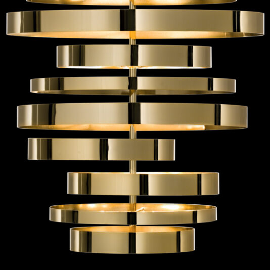 Large Contemporary Chandelier The Large Contemporary Chandelier, designed with a sleek gold-toned finish, showcases multiple stacked circular bands of varying sizes. These evenly spaced rings emit a warm, ambient light against a black background, making it an ideal fixture for modern interiors.