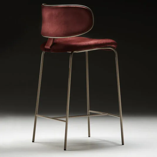 The Luxury Mid Century Style Bar Stool boasts a sleek and modern design, featuring a red upholstered seat and backrest that exude luxury. Its minimalist aesthetic is highlighted by thin metal legs and a footrest, all set against a dark gradient background.