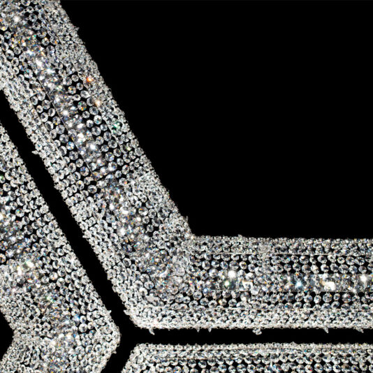 Luxury Octagonal Crystal Pendant Chandelier Close-up of black fabric adorned with intricate, sparkling silver sequins that resemble a Luxury Octagonal Crystal Pendant Chandelier. The reflective sequins create a dazzling effect, highlighting the luxurious texture and detail of the embellishments.