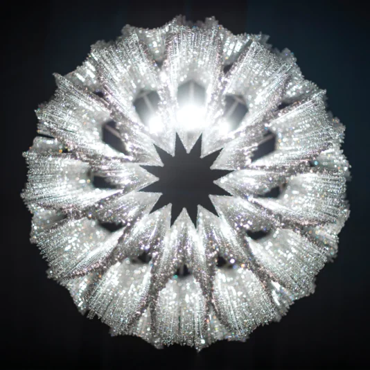 Luxury Suspended Crystal Pendant Chandelier A radiant, detailed spherical sculpture with starburst-like spikes and sparkling details resembles the Luxury Suspended Crystal Pendant Chandelier against a dark backdrop.