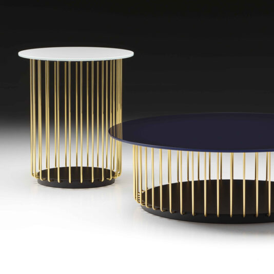 Contemporary Round Glass Coffee Table Two contemporary round tables with thin gold vertical rods as the base. One table has a white top and is taller, while the other has a black top and is shorter. Both tables are placed on a sleek black and white surface. The elegant design of these Contemporary Round Glass Coffee Tables rivals any modern glass coffee table.