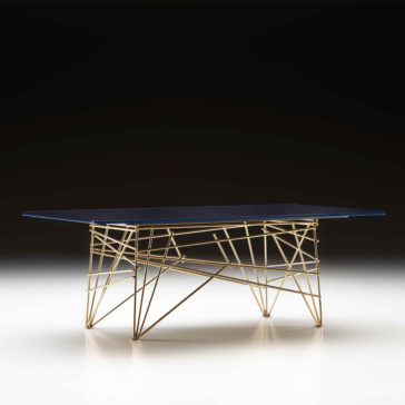 The Modern Rectangular Glass Coffee Table features a sleek dark glass top and a distinctive base composed of intersecting gold metal rods, forming an airy geometric pattern. Set against a dark gradient background, the table exudes contemporary and artistic flair.