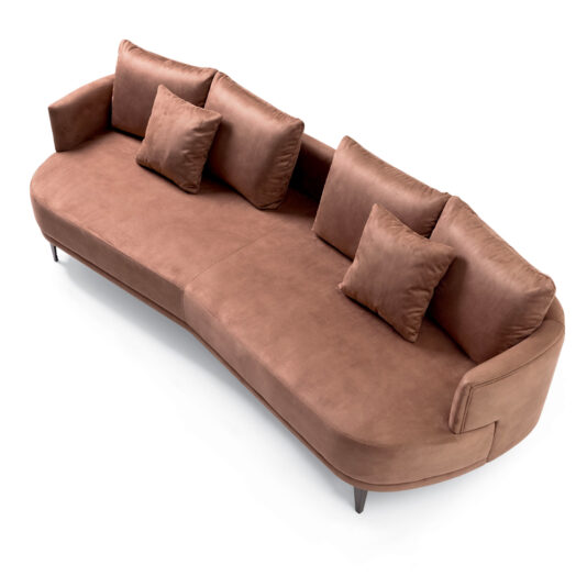 The High End Contemporary Curved Sofa, upholstered in luxurious modern brown velvet and accompanied by four matching throw pillows, boasts a sleek design with short black legs. It is perfectly showcased against a white background.