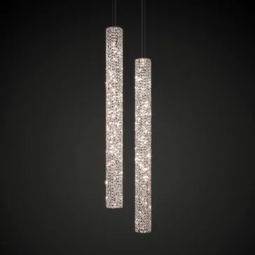 Luxury Vertical Crystal LED Chandelier Two sleek, cylindrical pendant lights from the Luxury Vertical Crystal LED Chandelier collection hang from the ceiling. Each light is adorned with an intricate, sparkling crystal design, casting a glamorous glow against a dark background. These luxury fixtures resemble their namesake and are positioned at slightly different heights.