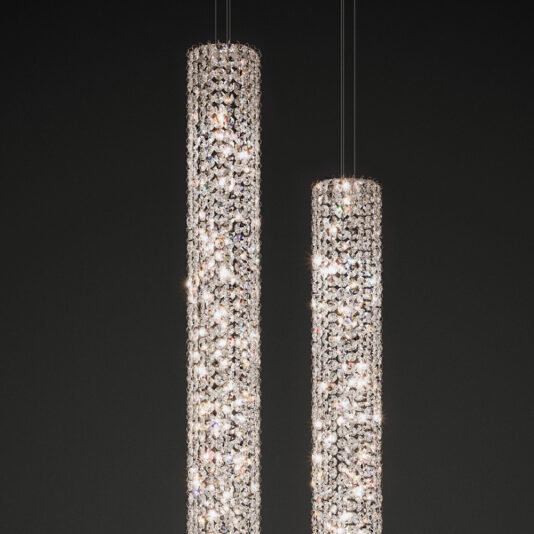 A close-up view of two Luxury Vertical Crystal LED Chandeliers with a myriad of sparkling crystals, emitting a radiant glow against a dark background. These lights are suspended from thin wires, showcasing their elegant, modern design reminiscent of cylindrical pendant lights.