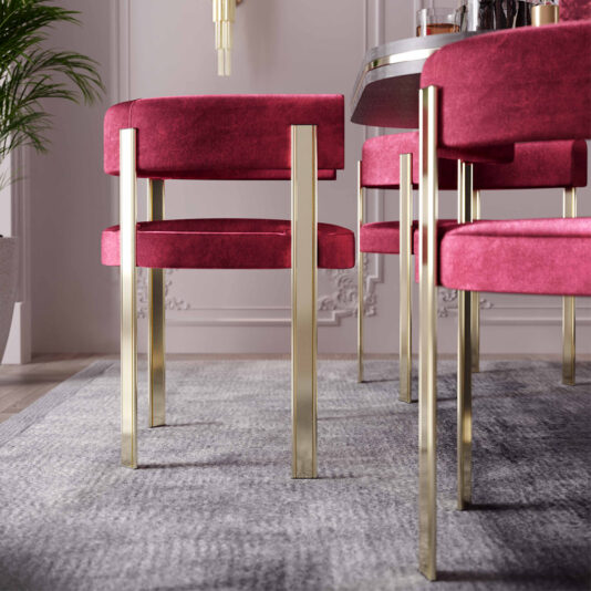 Modern Curved Dining Chair Modern Curved Dining Chairs with gold metallic legs and plush red cushions are arranged around a table. The seating is placed on a gray rug in an elegant room with light-colored walls, subtle wall molding, and a potted plant in the corner.