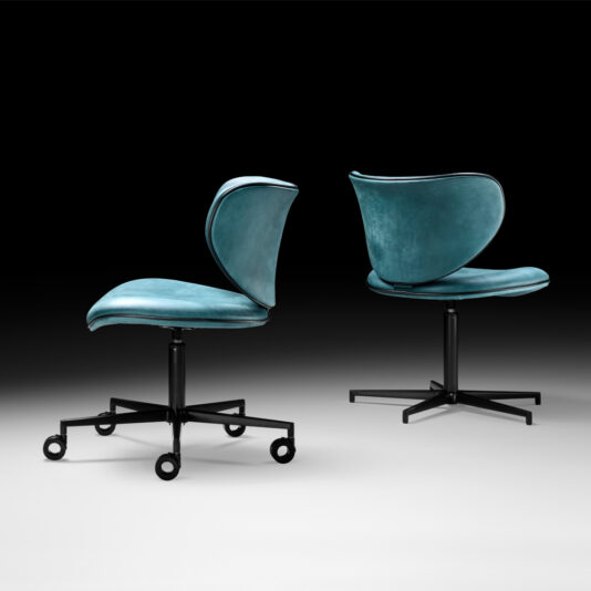 Retro Inspired Swivel Office Chair Two Retro Inspired Swivel Office Chairs, featuring teal velvet upholstery and black metal bases, are displayed against a gradient black-to-white background. One chair is shown from the front and the other from the back, both on casters with curved backrests.