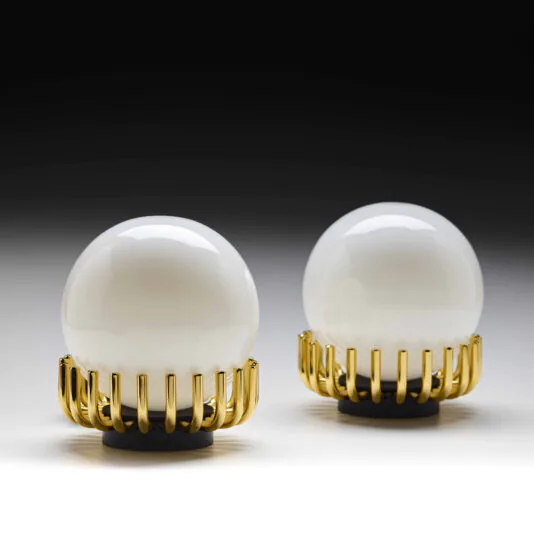 Small Contemporary Sphere Table Lamp Two Small Contemporary Sphere Table Lamps, featuring white spherical designs, are elegantly supported by golden claw-like bases. They are set against a gradient backdrop that transitions from dark at the top to light at the bottom, creating a sophisticated contrast.
