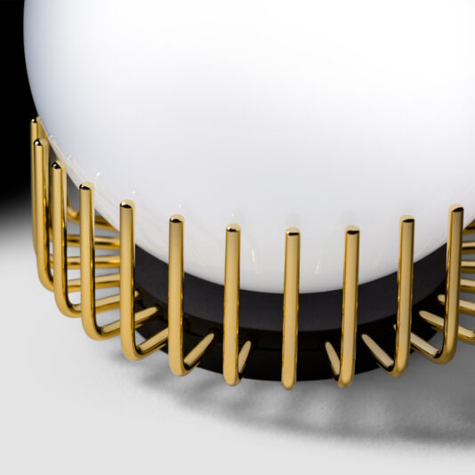 Small Contemporary Sphere Table Lamp Close-up of the Small Contemporary Sphere Table Lamp, showcasing a spherical white light bulb that is partially enveloped by a curved, gold-colored metal grille. The intricate grille encases the lower portion of the bulb, adding a stylish and sophisticated design element to the lamp.