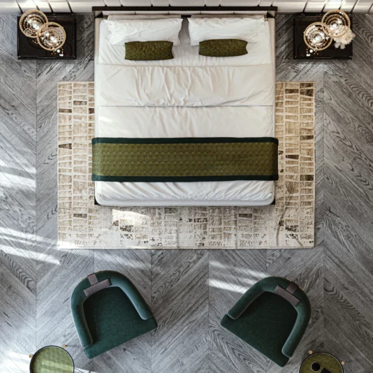Art Deco Style Bed With Tall Headboard An aerial view showcases a modern Art Deco Style Bedroom: a large Art Deco Style Bed With Tall Headboard, dressed in white linens with green accents. Two small decorated tables flank the bed, while two green chairs face it atop a herringbone-patterned wooden floor and rug.