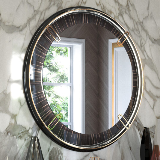 A Backlit Art Deco Style Veneer Round Mirror, featuring an elegant dark wood and gold frame, is mounted on a marble wall. Sunlight filters through a window, illuminating the room and enhancing the backlit veneer accents. The reflection captures a glimpse of a wooden herringbone wall and green foliage outside, with decor items arranged below.
