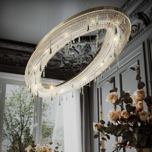 The elegant room was adorned with a Contemporary Crystal Chandelier With Coloured Drops, featuring an oval shape adorned with glittering accents and suspended green glass drops. It hung majestically from the ornate, dark ceiling, casting shimmering light throughout. In the foreground, a bouquet of white roses complemented the enchanting view of a large window framing a green tree outside.