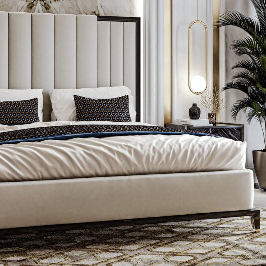 A modern, luxurious bedroom featuring the High End Art Deco Style Bed adorned with patterned pillows and a matching throw. A large potted plant and a sleek bedside table with a round lamp enhance the sophisticated decor, perfectly complemented by a geometric-patterned carpet.