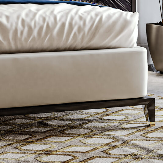 A close-up image showcases the corner of the High End Art Deco Style Bed with a beige mattress and blue bedding. The minimalist design features metallic legs, complemented by a textured carpet in shades of grey and gold, with a black plant pot nearby.