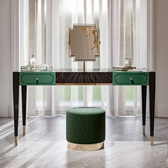 A high-end Art Deco Style Dressing Table with a glossy wooden top and green drawers is positioned in front of sheer curtains. Atop the table sits a geometric mirror, a candle, and a diffuser. Complementing the setup is a round, green upholstered stool with a gold base placed in front of the dressing table.