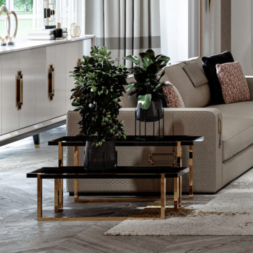 High End Double Tiered End Table A modern living room featuring a beige sofa adorned with pillows, a set of black nested coffee tables with gold legs holding potted plants, and the High End Double Tiered End Table by the white sideboard with gold handles. Light gray curtains frame the large window, and wood-patterned tiles cover the floor.