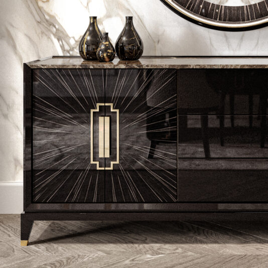 High End Veneer And Marble Sideboard The High End Veneer And Marble Sideboard with a black veneer finish and gold geometric sunburst designs on its doors stands against a marble wall. Three black vases of varying shapes and sizes adorn the top, while the herringbone wood floor adds an elegant touch.