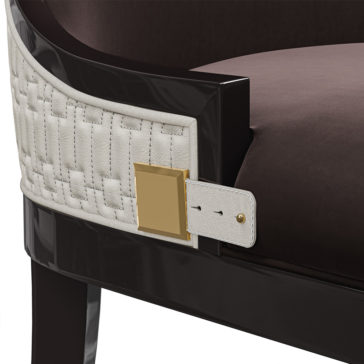 Luxury Art Deco Style Veneer Dining Set Close-up of an elegant chair from the Luxury Art Deco Style Veneer Dining Set, featuring dark polished wood and a woven white leather backrest. The leather is adorned with a square gold buckle detail on the side, adding a touch of sophistication to this luxury piece. The seat cushion is covered in a rich brown fabric.