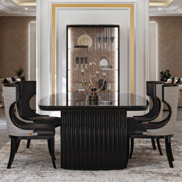 Luxury Art Deco Style Veneer Dining Set The Luxury Art Deco Style Veneer Dining Set boasts a rectangular black marble table with a ribbed black base, complemented by four sophisticated upholstered chairs with patterned backs. Completing the set is an elegant display cabinet adorned with decorative items and featuring a warm metallic backdrop.