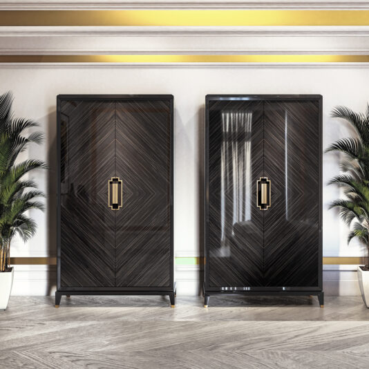 The image showcases two sleek, black High End Veneer Wardrobe Cabinets with gold handles, positioned side-by-side against a luxurious interior wall. They are flanked by potted plants and placed on a floor featuring a herringbone pattern. The wall's gold trim enhances the elegant ambiance.