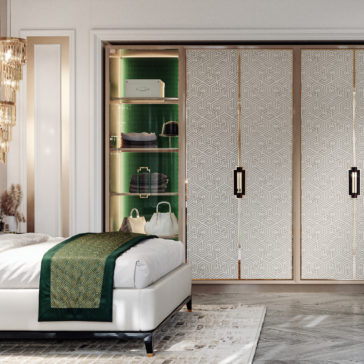 Large High End Integrated Wardrobe Luxurious bedroom with a minimalist design featuring a bed adorned with a green and gold patterned throw, a patterned sliding door, and an illuminated open shelf displaying bags and accessories. The room boasts elegant lighting, a calm, sophisticated ambiance, and includes the Large High End Integrated Wardrobe for ample storage.