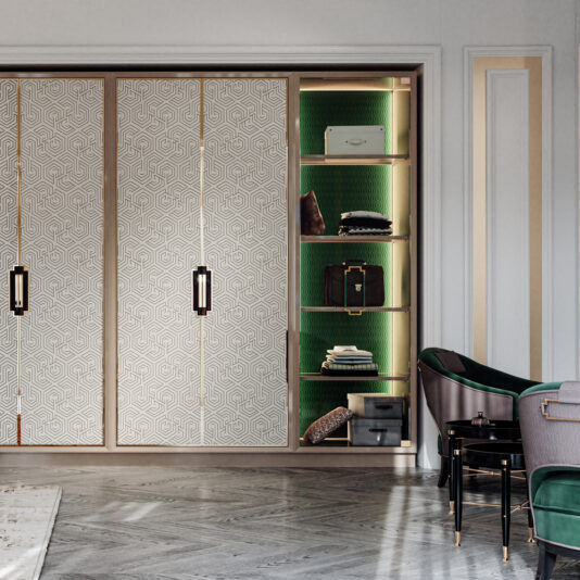 Large High End Integrated Wardrobe The Large High End Integrated Wardrobe features elaborate geometric patterned sliding doors, which, when partially open, reveal shelves set against a green textured background. Inside, neatly organized accessories and storage boxes are displayed. Complementing the wardrobe on the right are stylish chairs with dark green upholstery.