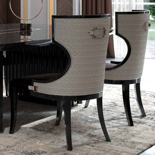 A stylish modern dining room featuring two Luxury Art Deco Style Dining Chairs with high backs, gray textures, and black and gold accents. The furniture is set around a sleek black dining table. Large windows in the background allow natural light to brighten the elegant, carpeted space.
